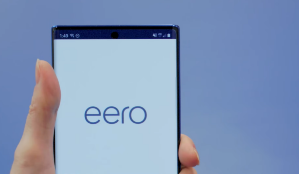A close-up of a hand holding a smartphone with the word "eero" on the screen